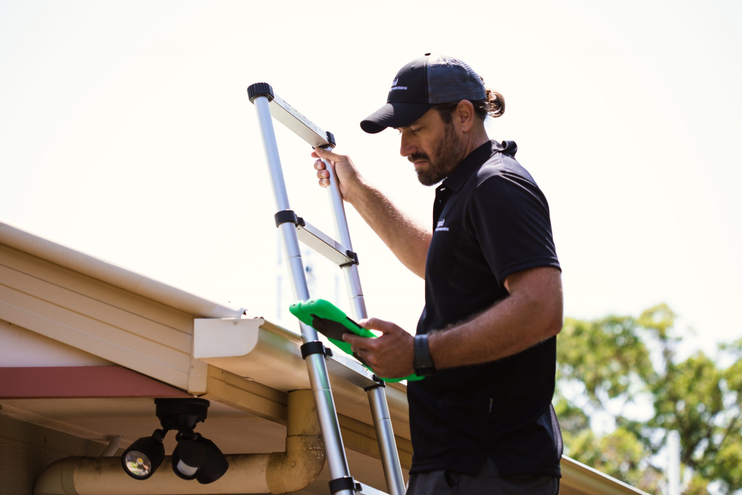 Roof inspector checks blocked guttering 